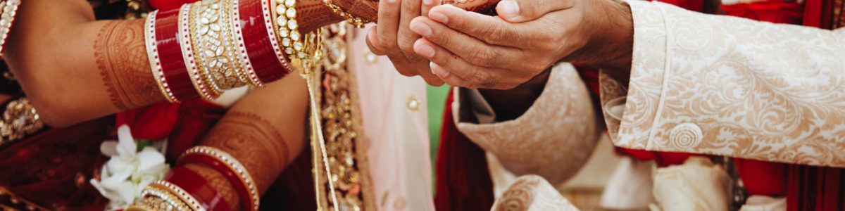 Hands of indian bride and groom intertwined together making authentic wedding ritual